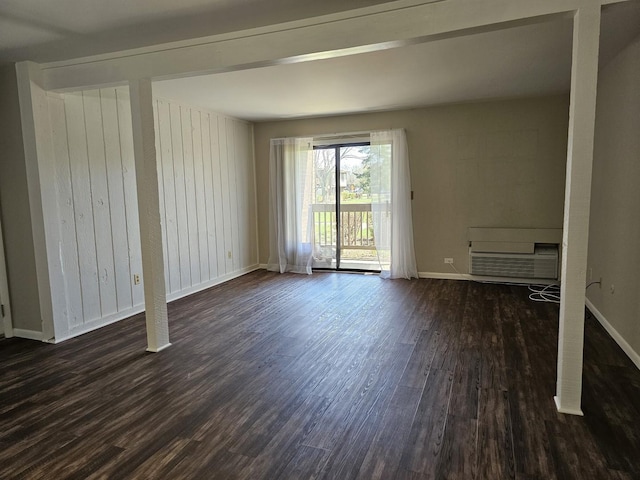 spare room with baseboards and dark wood finished floors