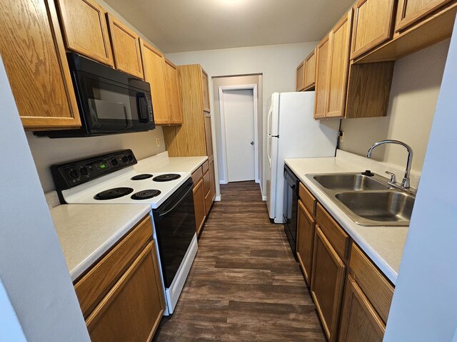 kitchen featuring light countertops, a sink, black appliances, and dark wood-type flooring