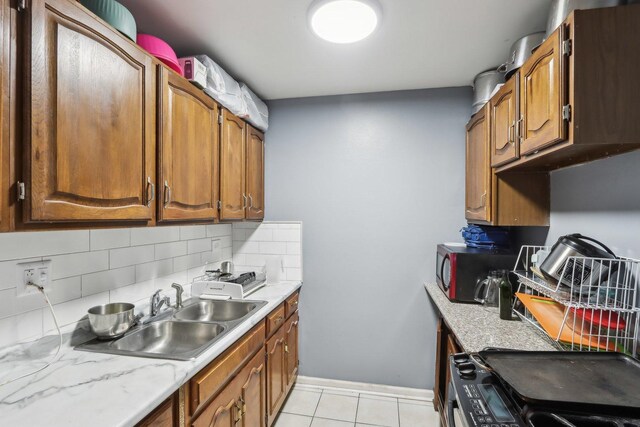 600 Mesa Dr Unit 103, Hoffman Estates, IL 60169 - kitchen featuring a sink, stove, black microwave, tasteful backsplash, and light countertops