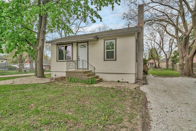 413 Wheeler Ave, Joliet, IL 60436 - view of front of home with fence, a chimney, roof with shingles, and a front yard