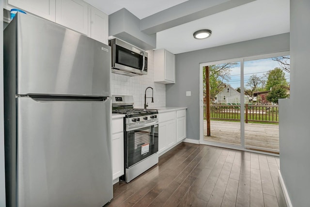 413 Wheeler Ave, Joliet, IL 60436 - kitchen featuring light countertops, dark wood finished floors, stainless steel appliances, baseboards, and backsplash