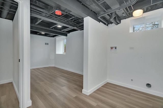 413 Wheeler Ave, Joliet, IL 60436 - below grade area with baseboards, a healthy amount of sunlight, and wood finished floors