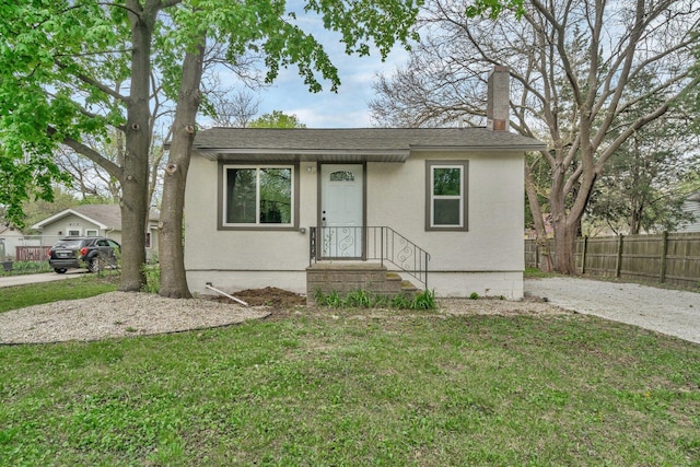 413 Wheeler Ave, Joliet, IL 60436 - bungalow-style house with fence, a chimney, a front yard, and stucco siding
