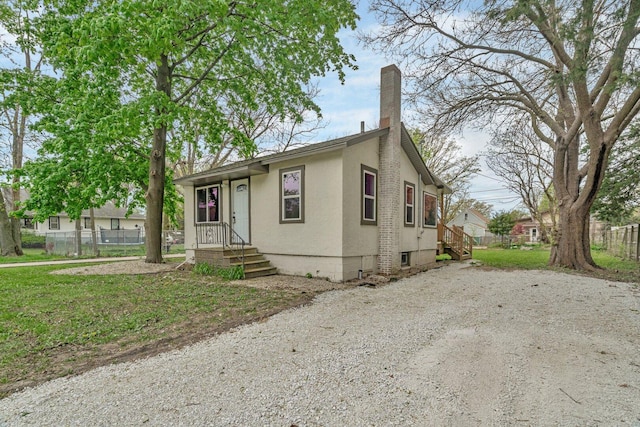 413 Wheeler Ave, Joliet, IL 60436 - view of front of property featuring fence, a chimney, and stucco siding