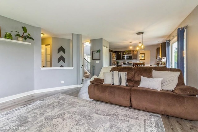 4524 Deames St, Plano, IL 60545 - living area featuring stairway, baseboards, wood finished floors, and a chandelier