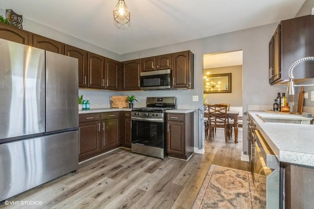 4524 Deames St, Plano, IL 60545 - kitchen with dark brown cabinets, light countertops, a sink, stainless steel appliances, and light wood-style flooring