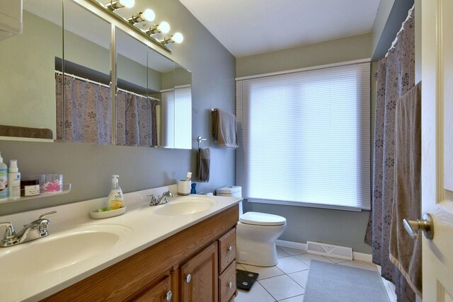 full bath with visible vents, a sink, tile patterned flooring, and a wealth of natural light