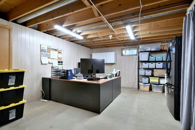 office featuring wooden walls and concrete floors