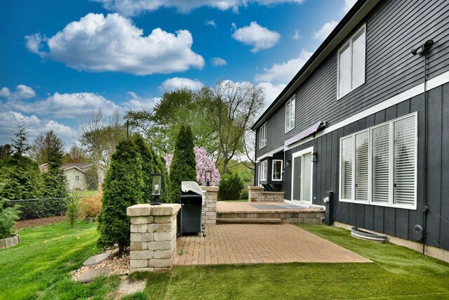 view of patio featuring fence and a grill