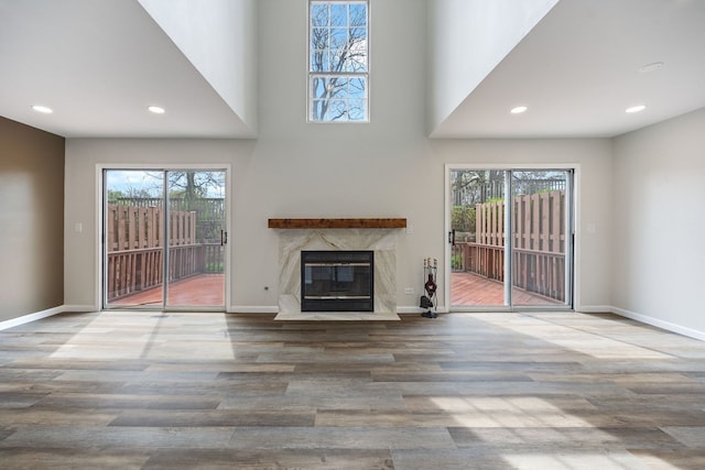 282 Ascot Ln, Streamwood, IL 60107 - unfurnished living room featuring plenty of natural light, a high end fireplace, wood finished floors, recessed lighting, and baseboards