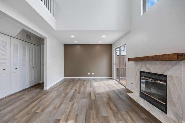 282 Ascot Ln, Streamwood, IL 60107 - unfurnished living room with a high ceiling, a high end fireplace, wood finished floors, recessed lighting, and baseboards