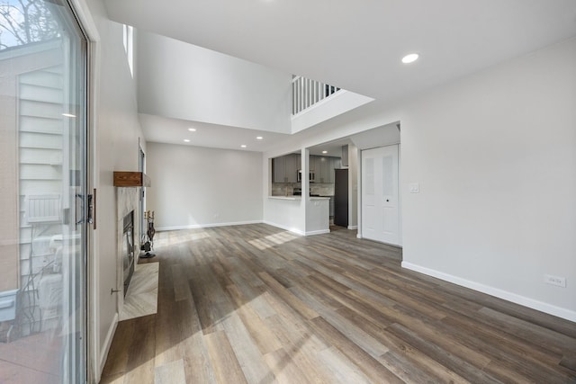 282 Ascot Ln, Streamwood, IL 60107 - unfurnished living room with a glass covered fireplace, dark wood-type flooring, recessed lighting, baseboards, and a high ceiling