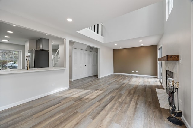 282 Ascot Ln, Streamwood, IL 60107 - unfurnished living room featuring a premium fireplace, light wood-style floors, stairway, baseboards, and recessed lighting