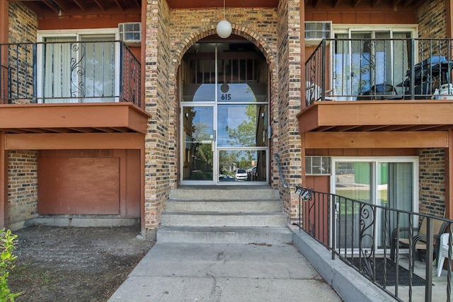 615 Hill Dr Unit 303, Hoffman Estates, IL 60169 - view of exterior entry featuring brick siding, a balcony, and board and batten siding