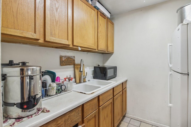615 Hill Dr Unit 303, Hoffman Estates, IL 60169 - kitchen featuring freestanding refrigerator, black microwave, a sink, light tile patterned floors, and light countertops