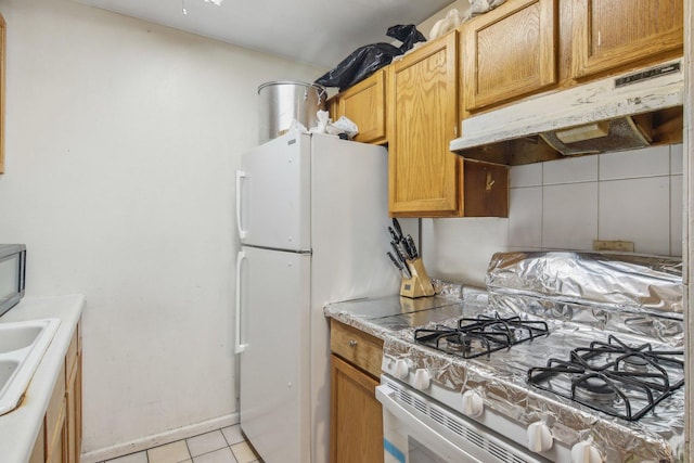 615 Hill Dr Unit 303, Hoffman Estates, IL 60169 - kitchen with under cabinet range hood, light tile patterned floors, gas range gas stove, and light countertops