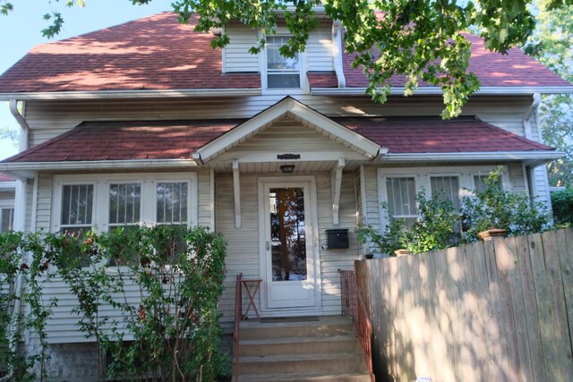 view of front of home featuring fence and roof with shingles