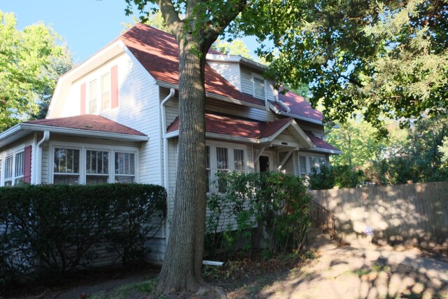 view of side of home with a shingled roof