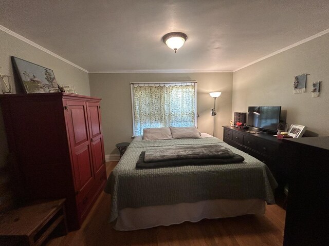 bedroom with crown molding and dark wood-type flooring