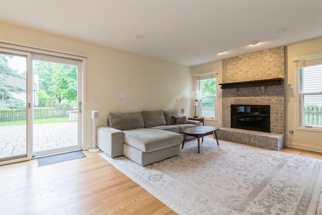 1161 Ardmore Dr, Naperville, IL 60540 - living area with plenty of natural light, light wood finished floors, a brick fireplace, and baseboards