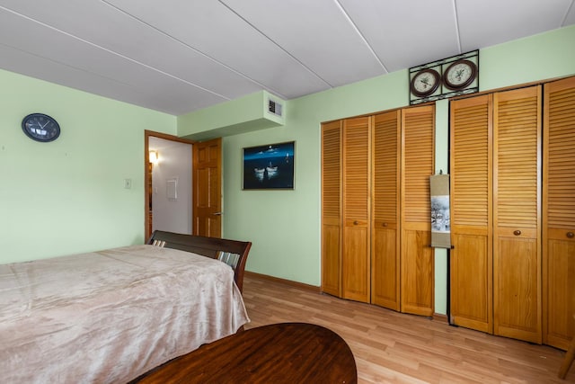 bedroom featuring baseboards, visible vents, and light wood-style floors