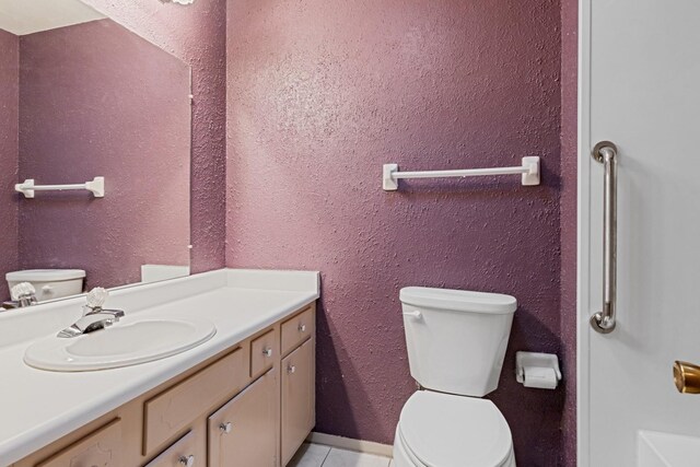 bathroom featuring toilet, tile patterned floors, and vanity