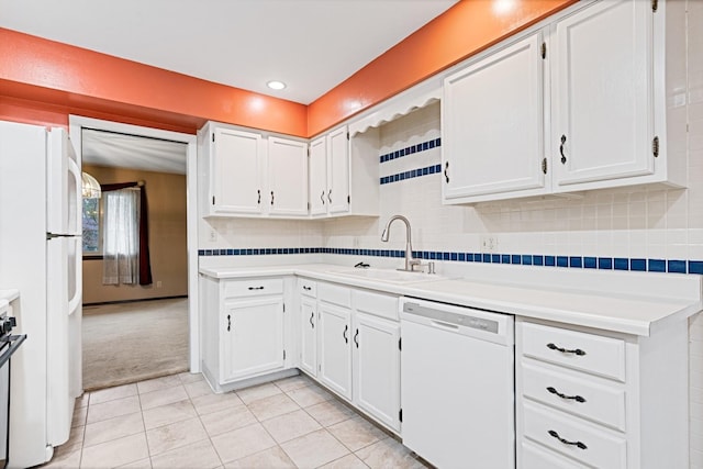 kitchen featuring a sink, white cabinets, light carpet, and white appliances