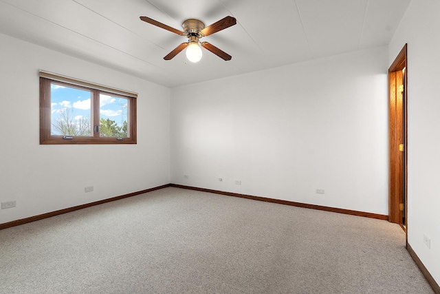 empty room featuring carpet floors, a ceiling fan, and baseboards