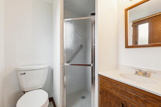 bathroom featuring vanity, toilet, and a shower stall