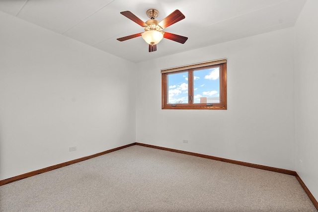 carpeted empty room with baseboards and a ceiling fan