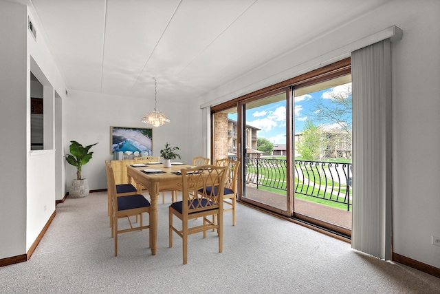 dining space featuring an inviting chandelier, light carpet, baseboards, and visible vents