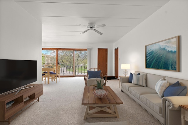 living area with carpet and ceiling fan