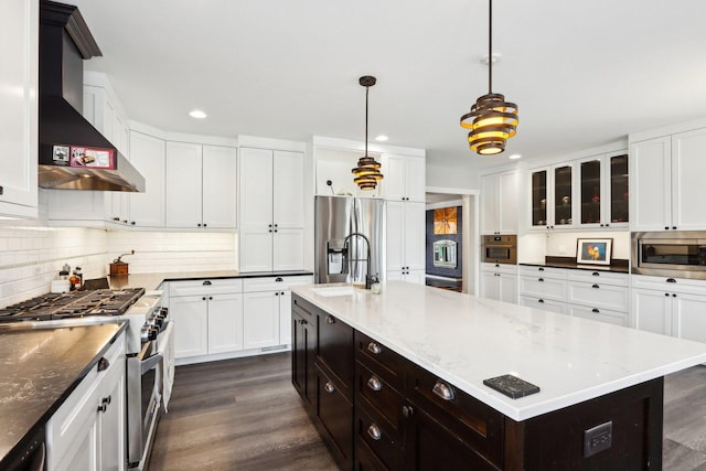 kitchen featuring a sink, white cabinetry, wall chimney range hood, appliances with stainless steel finishes, and recessed lighting