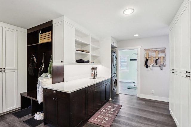 kitchen with stacked washer / drying machine, open shelves, white cabinetry, light countertops, and dark wood-style floors