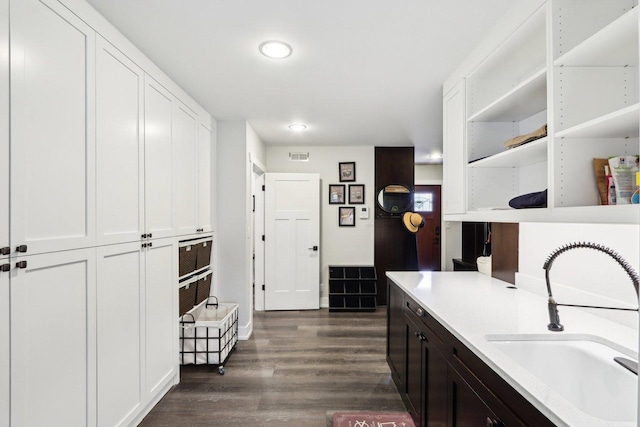 kitchen featuring a sink, open shelves, white cabinetry, and dark wood-type flooring