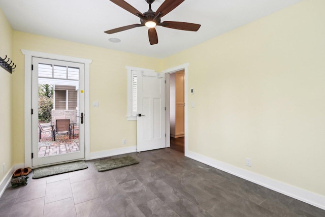 empty room featuring a ceiling fan and baseboards
