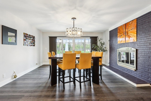 dining room with a chandelier, wood finished floors, and baseboards
