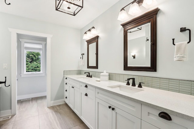 bathroom with baseboards, tasteful backsplash, double vanity, and tile patterned floors