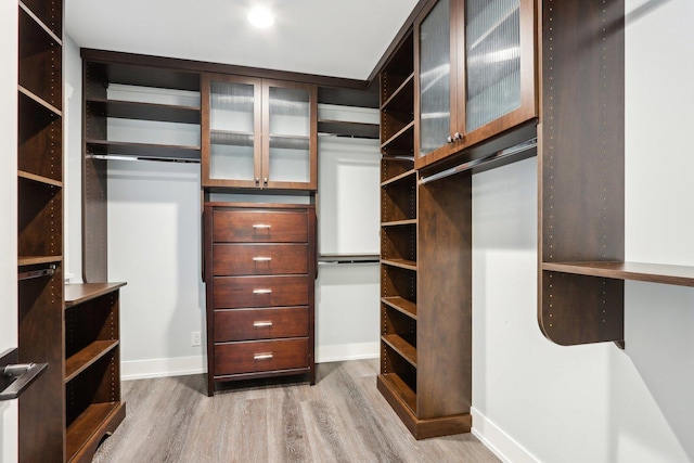 walk in closet with wood finished floors