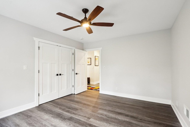 unfurnished bedroom featuring wood finished floors, baseboards, a closet, and a ceiling fan