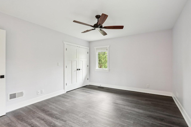 unfurnished bedroom featuring wood finished floors, baseboards, a ceiling fan, and a closet
