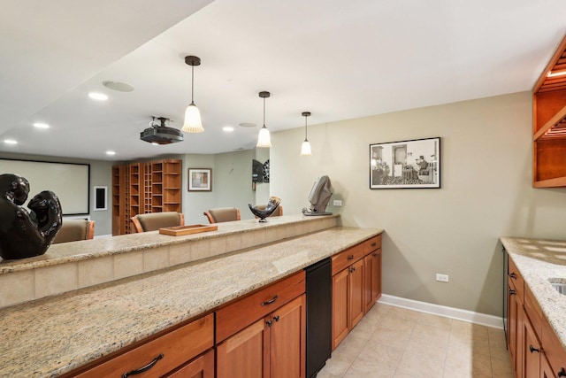 kitchen featuring recessed lighting, light stone counters, brown cabinets, baseboards, and hanging light fixtures