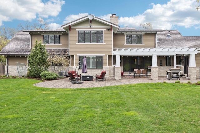 rear view of property featuring a chimney, a pergola, a patio, and stone siding