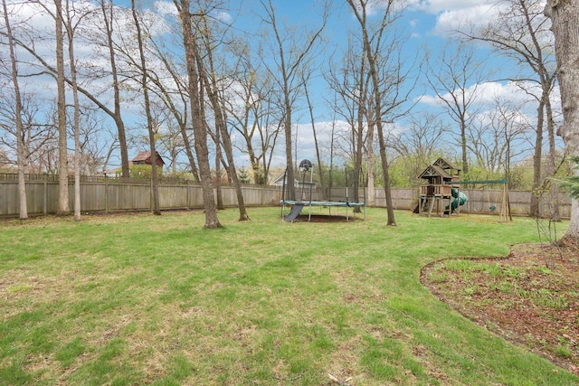 view of yard with a trampoline and a playground