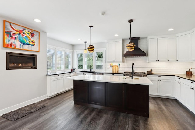kitchen featuring wall chimney range hood, dark wood-style flooring, backsplash, recessed lighting, and white cabinets