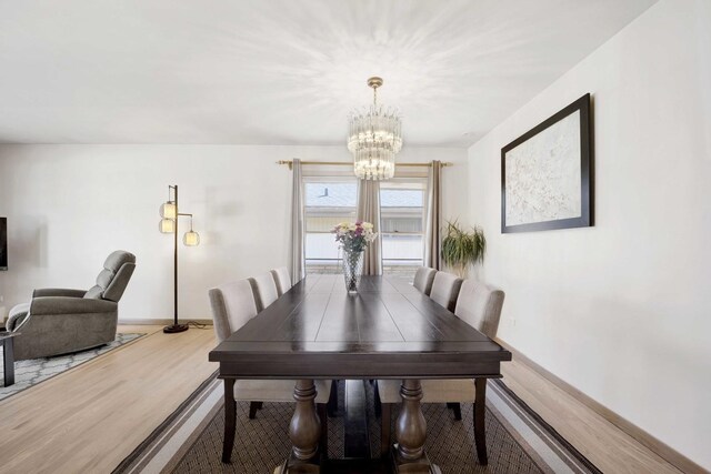 dining room featuring baseboards, a notable chandelier, and wood finished floors