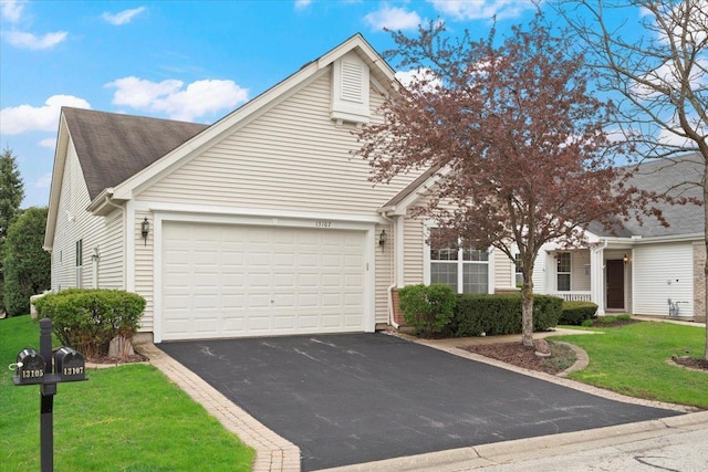 view of front facade featuring an attached garage, a front lawn, and aphalt driveway