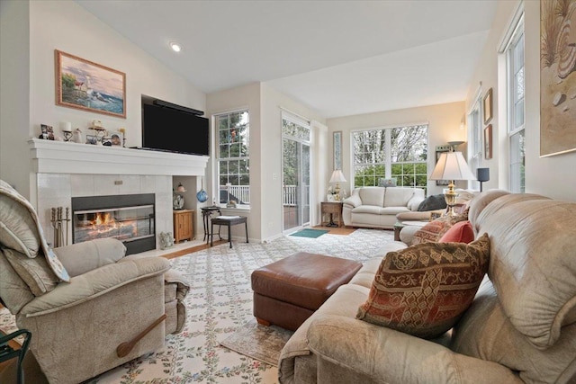 living room featuring a tiled fireplace, recessed lighting, baseboards, and lofted ceiling