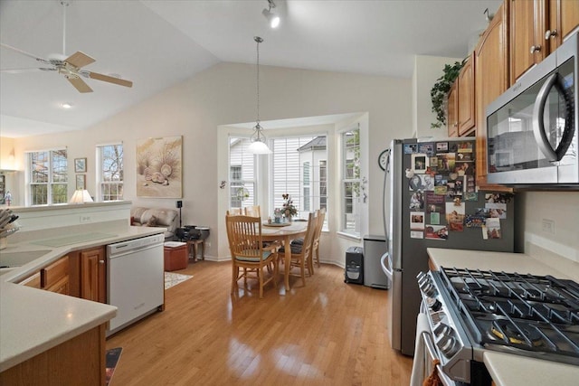 kitchen with light wood-style floors, appliances with stainless steel finishes, plenty of natural light, and brown cabinetry