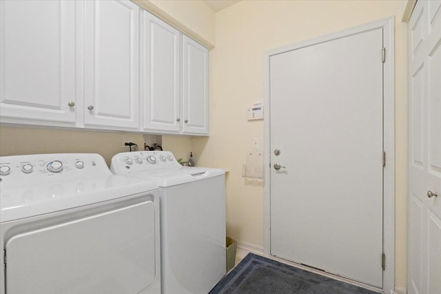 clothes washing area with cabinet space and washing machine and dryer